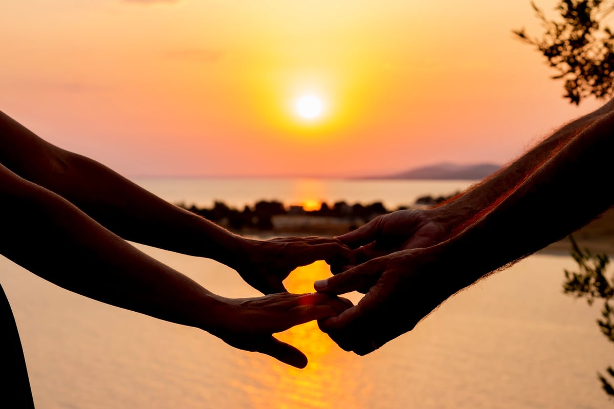 Couple holding hands at sunset